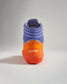 A vibrant pair of wrestling shoes featuring a striking combination of purple and orange colors with the brand name RUDIS prominently displayed on the heel