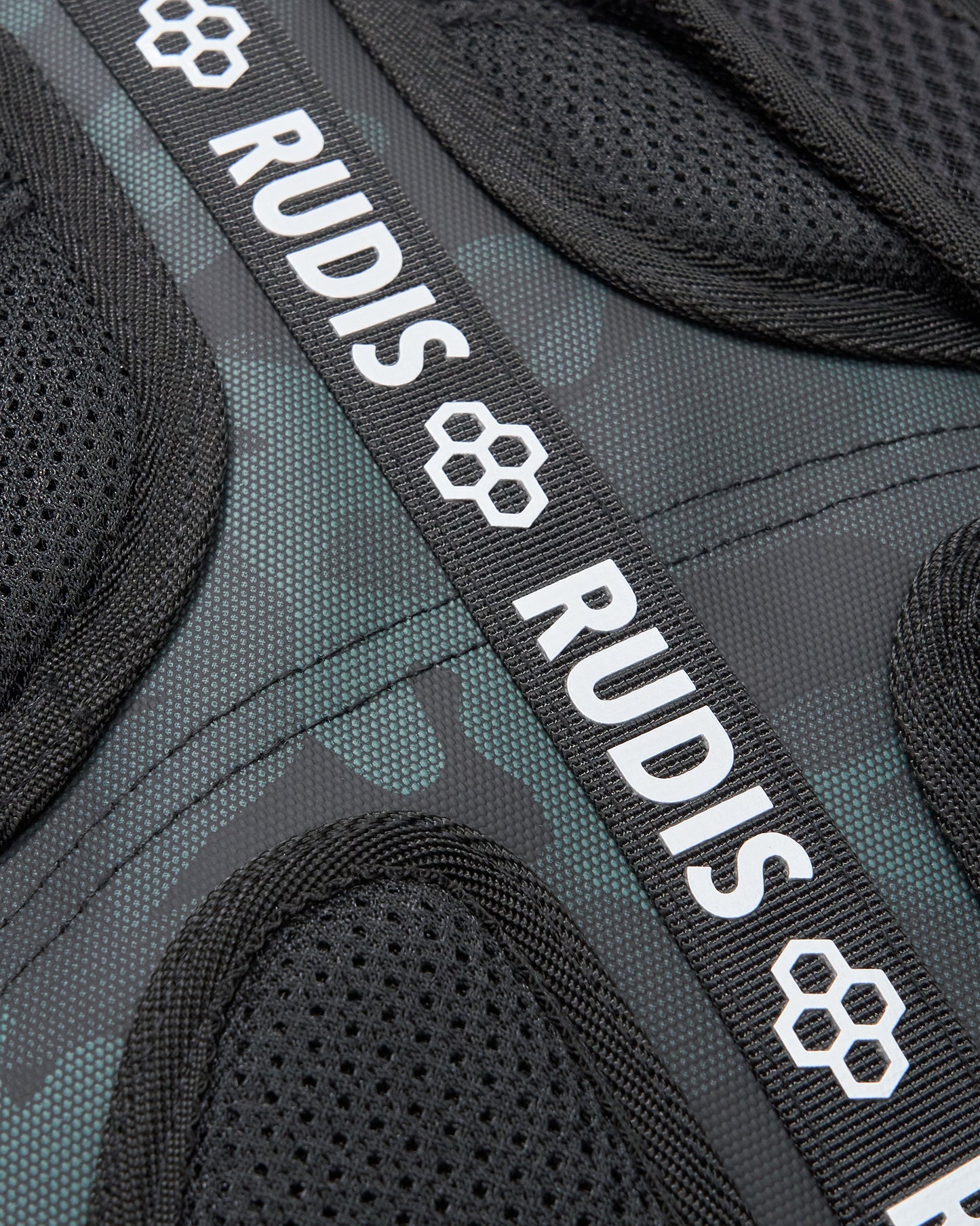 Close-up of a backpack with 'RUDIS' branding on a black and gray background
