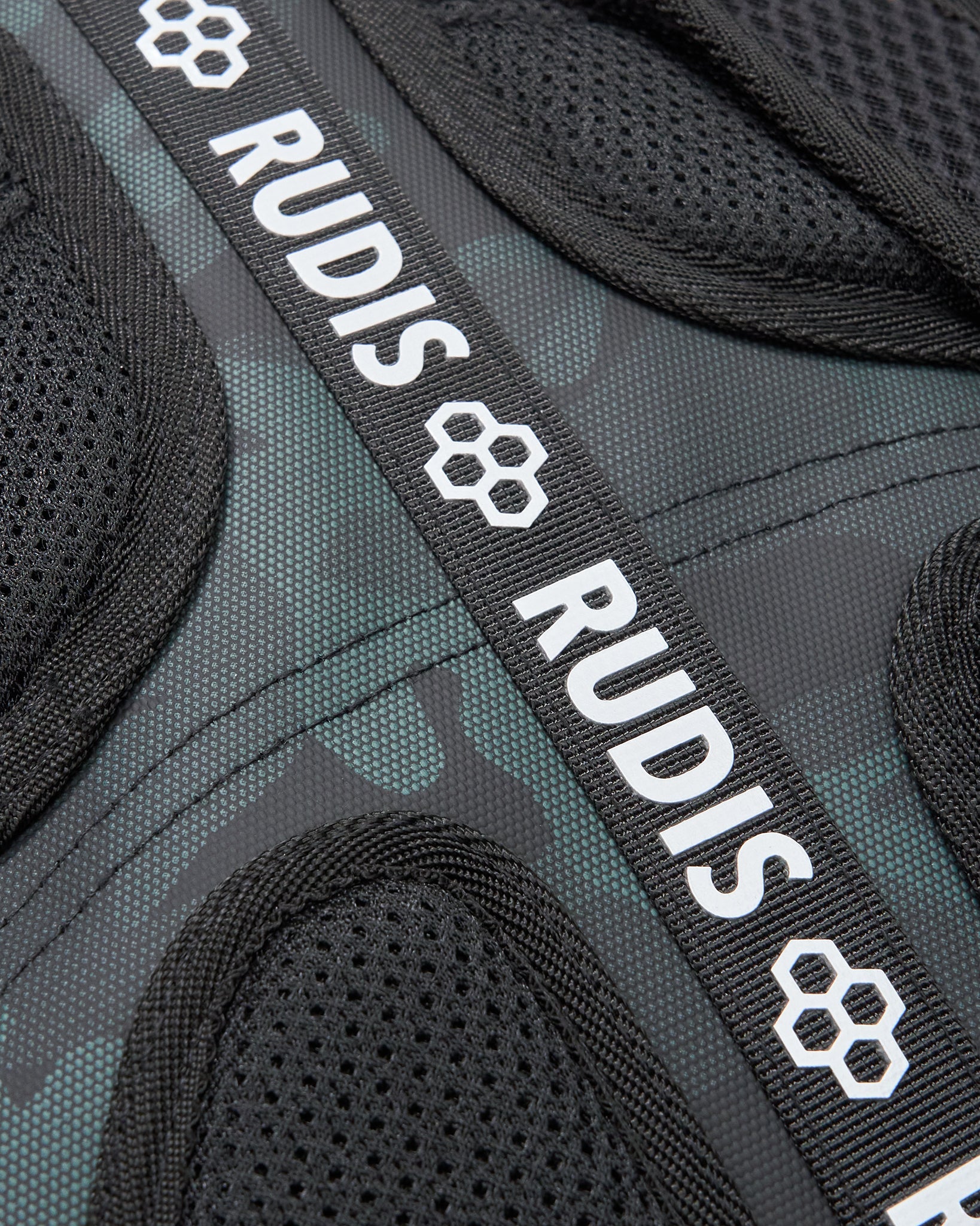 Close-up of a backpack with 'RUDIS' branding on a black and gray background