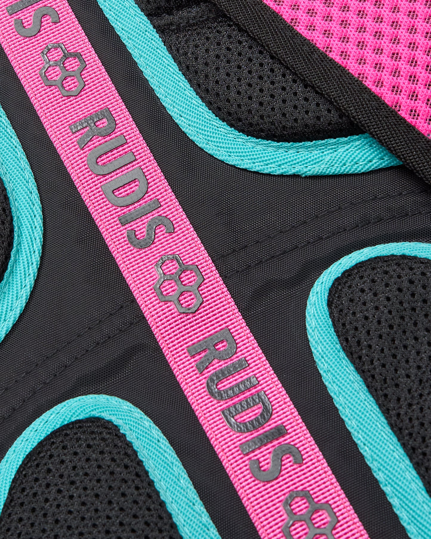 Close-up of a product with 'RUDIS' branding on a pink and teal strap.