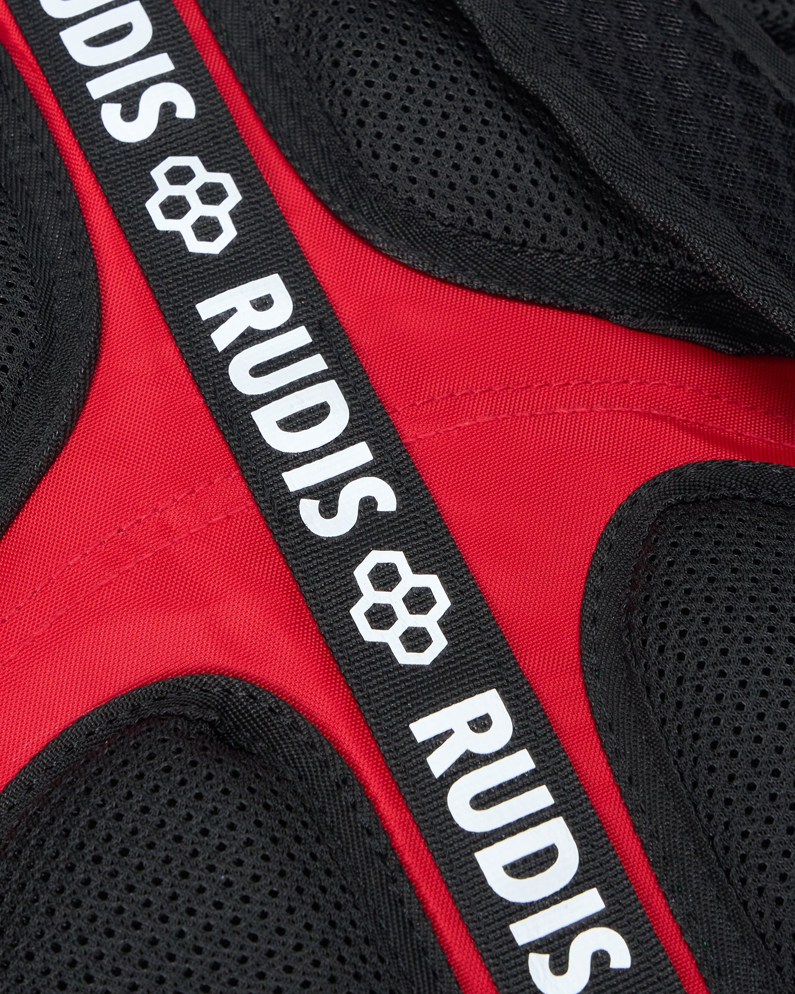 Red and black protective gear with 'RUDIS' branding on a strap.