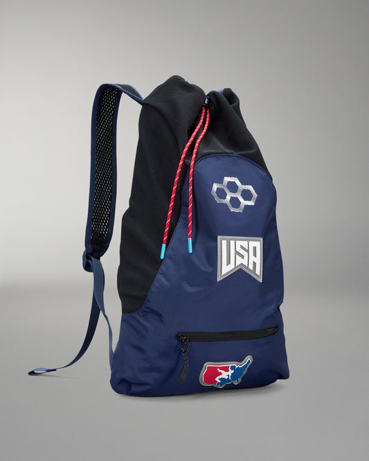 Blue and black backpack with USA Wrestling logo on a gray background