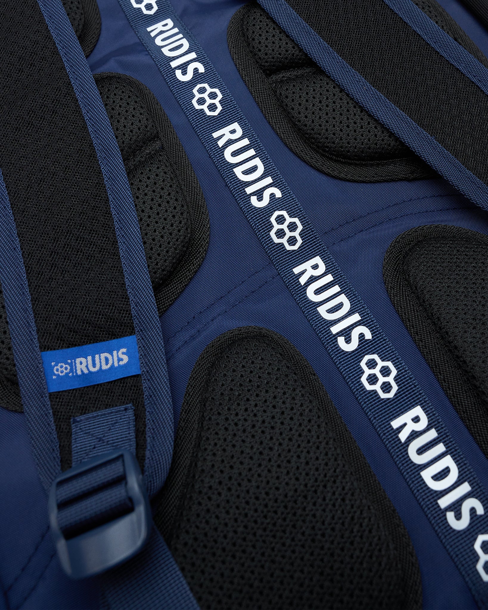 Close-up of a blue protective gear with 'RUDIS' branding on black padding.