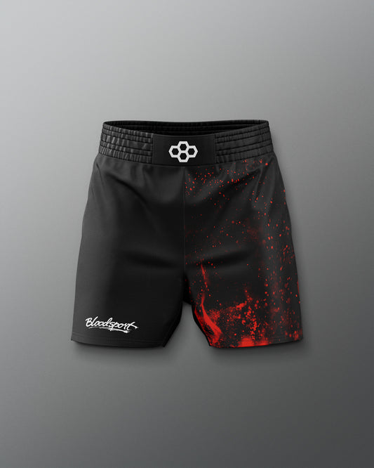 Black athletic shorts with red splatter design on a gray background