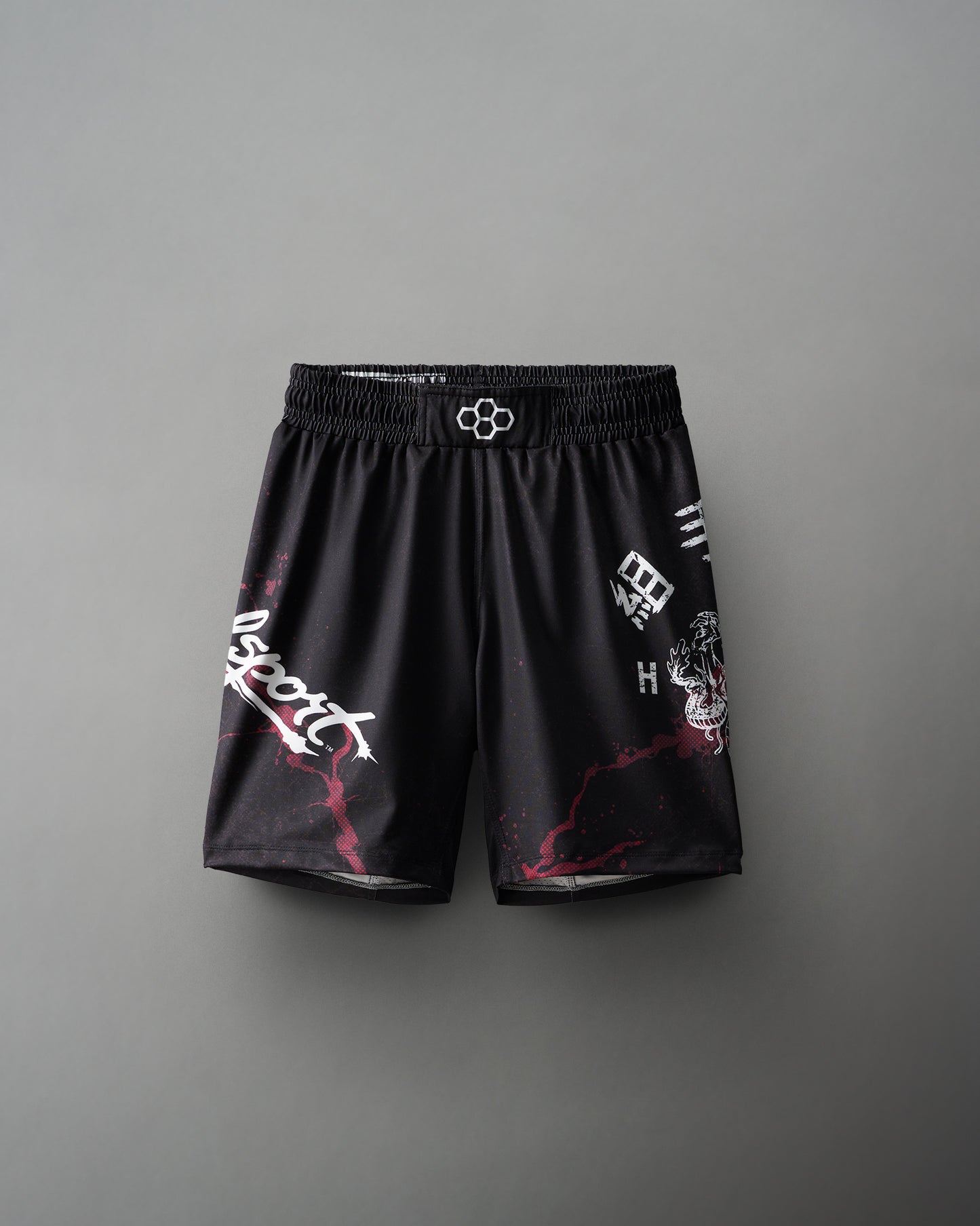 A pair of black wrestling shorts with red and white text and designs.