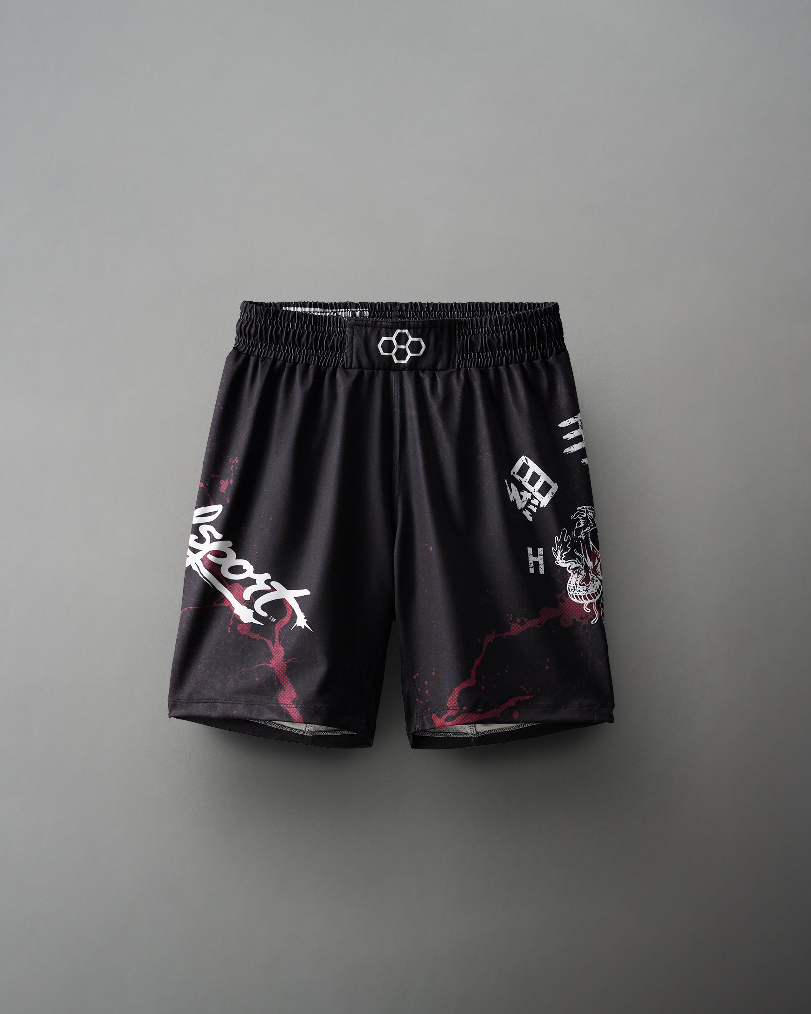 A pair of black wrestling shorts with red and white text and designs.