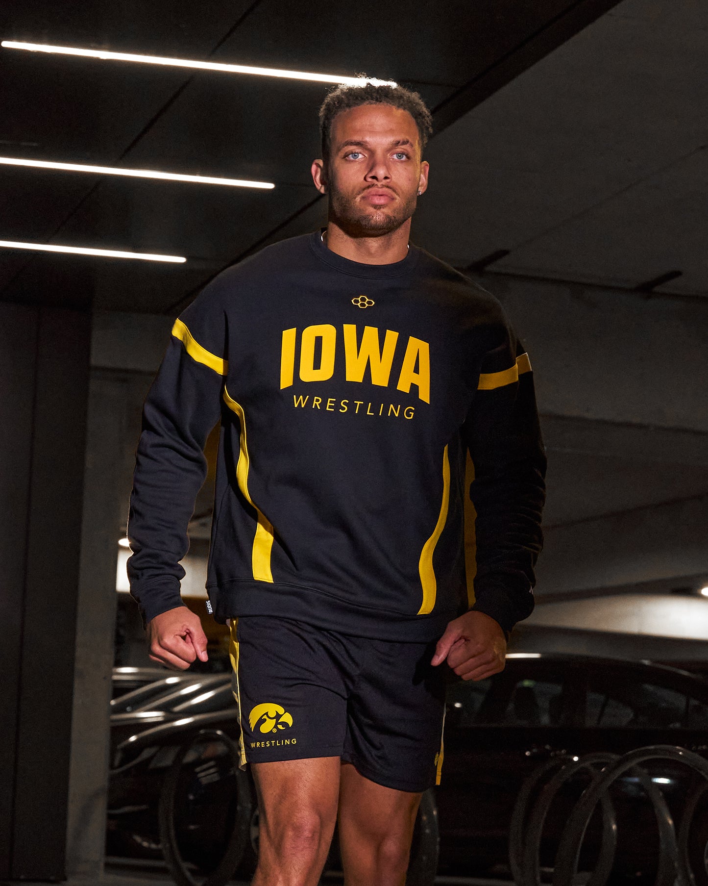 Person wearing an Iowa Wrestling outfit in a dark indoor setting