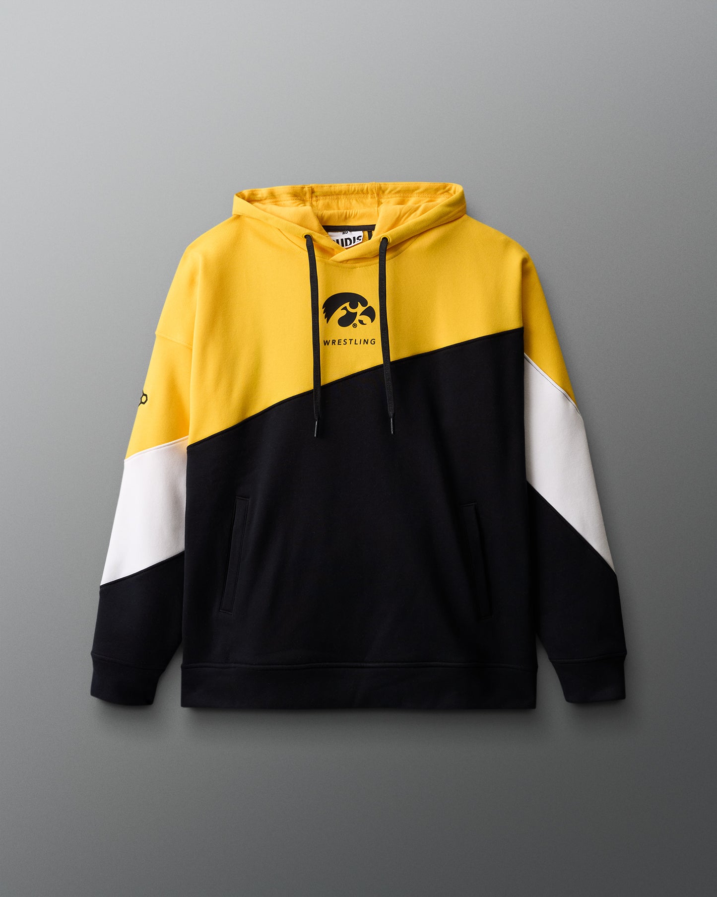 Color-blocked hoodie with yellow, black, and white sections on a gray background