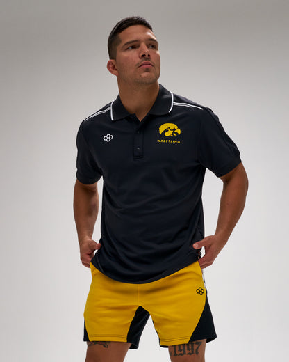 Man wearing a black and yellow sports outfit with a logo on a gray background