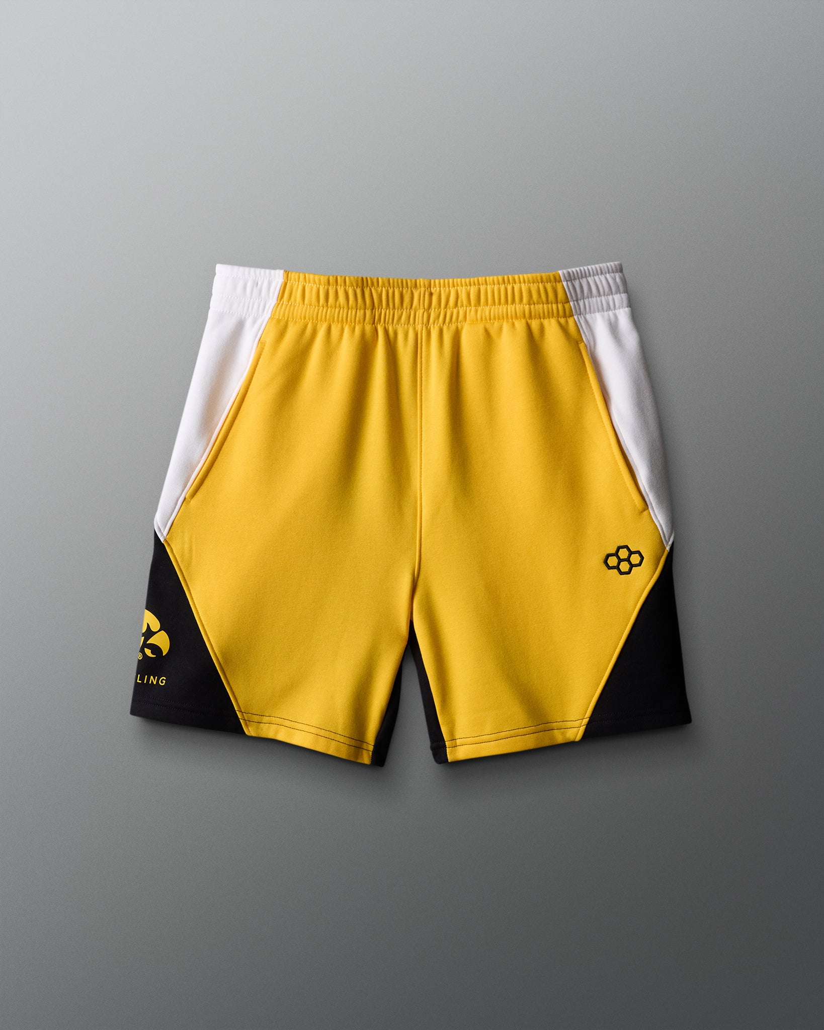 Yellow shorts with black and white accents on a gray background