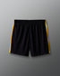 Black shorts with yellow stripes on a gray background