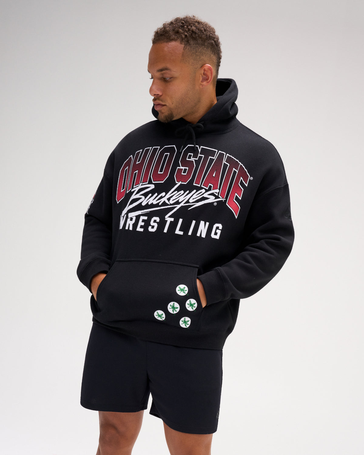 Model wearing the RUDIS Ohio State Buckeyes Relaxed Comfort Fleece Hoodie in black, featuring oversized Ohio State wrestling graphics, a drawstring hood and kangaroo pocket.