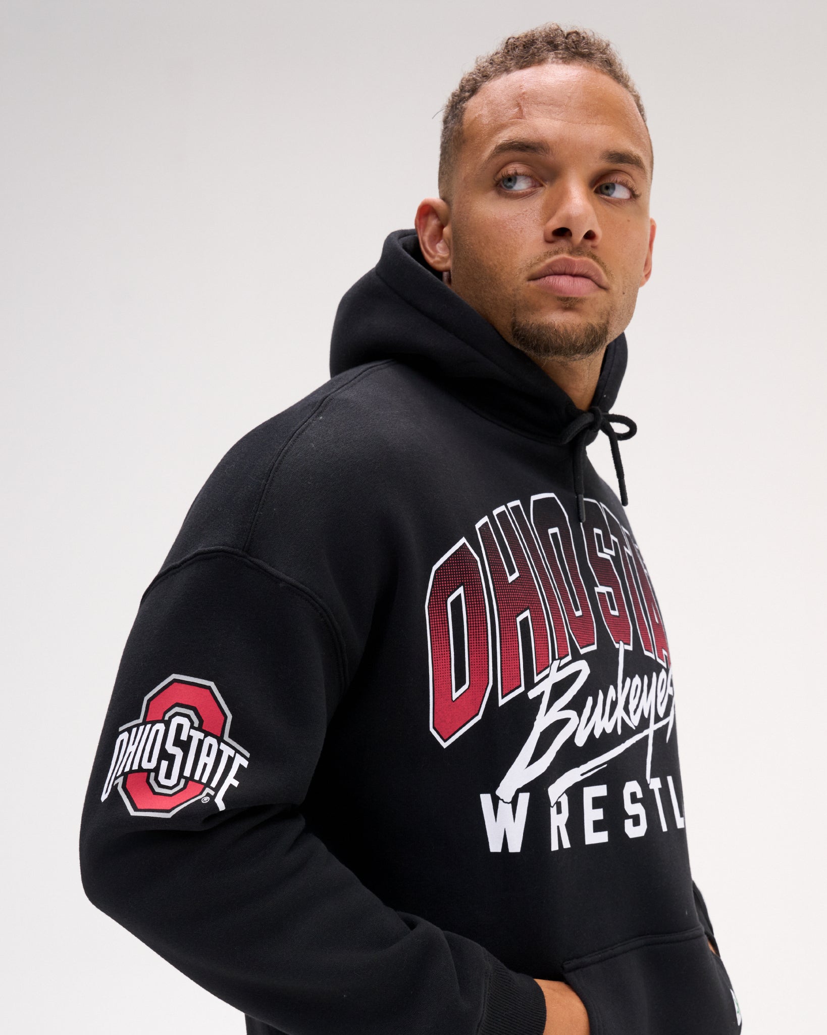 Close-up of the RUDIS Ohio State Buckeyes black fleece hoodie on a model, highlighting the Ohio State sleeve logo, Buckeyes Wrestling chest graphic and relaxed fit.
