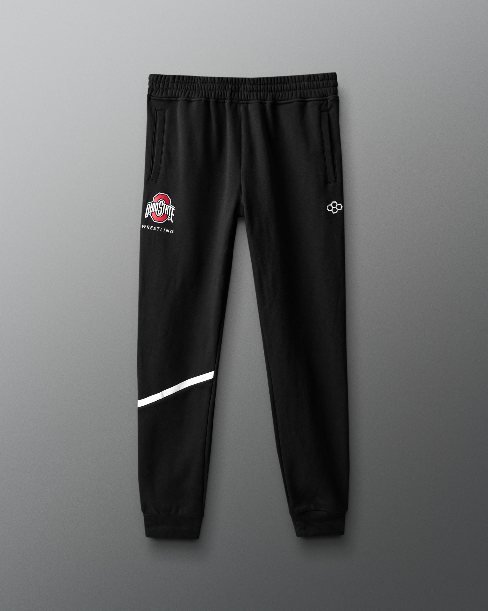 Black sweatpants with logos on a gray background