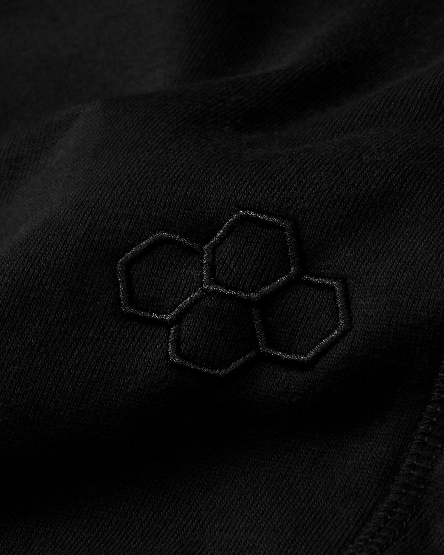 Close-up of a black fabric with embroidered hexagonal pattern