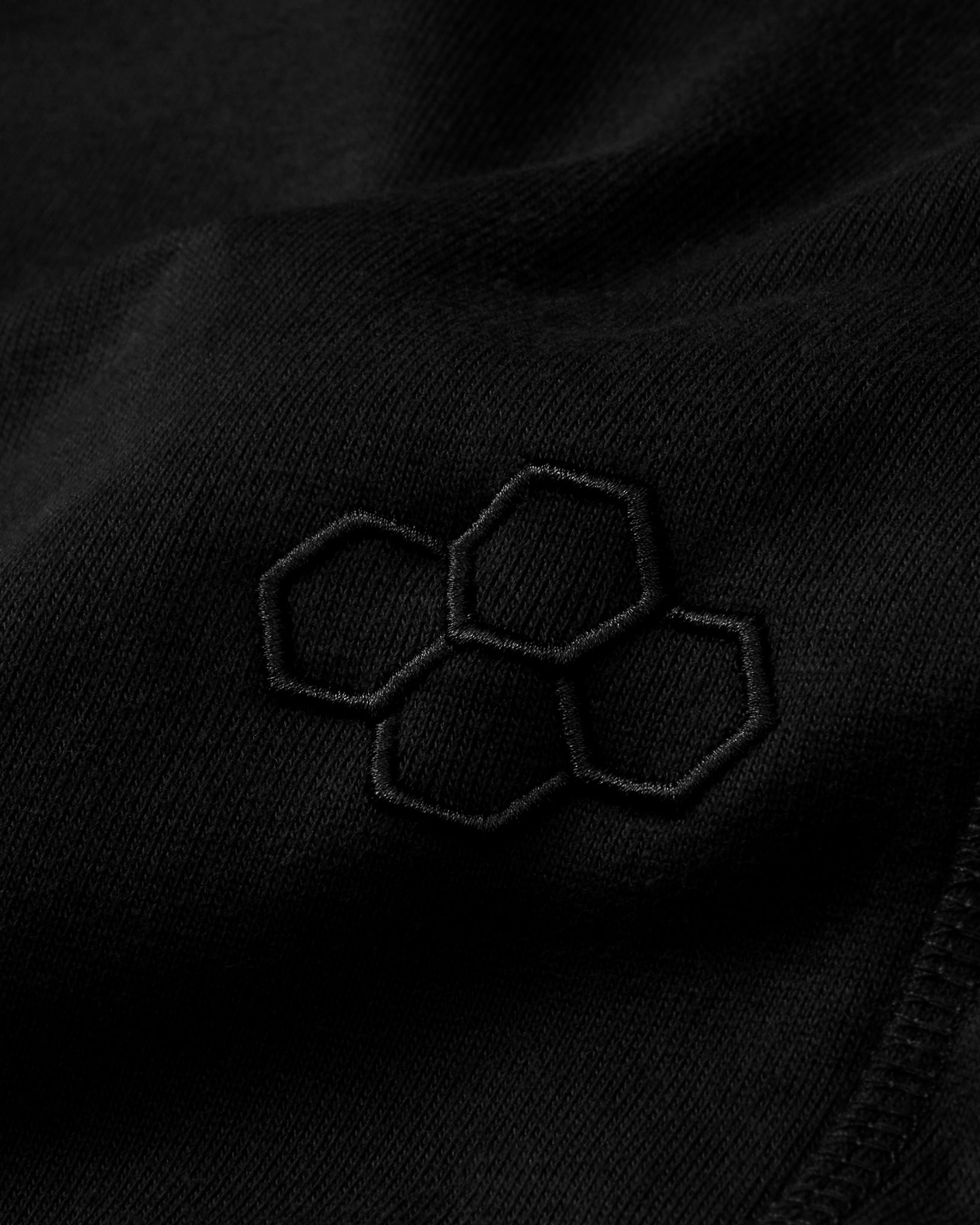 Close-up of a black fabric with embroidered hexagonal pattern