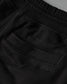 Black pants with 'RUDIS' branding on a dark background