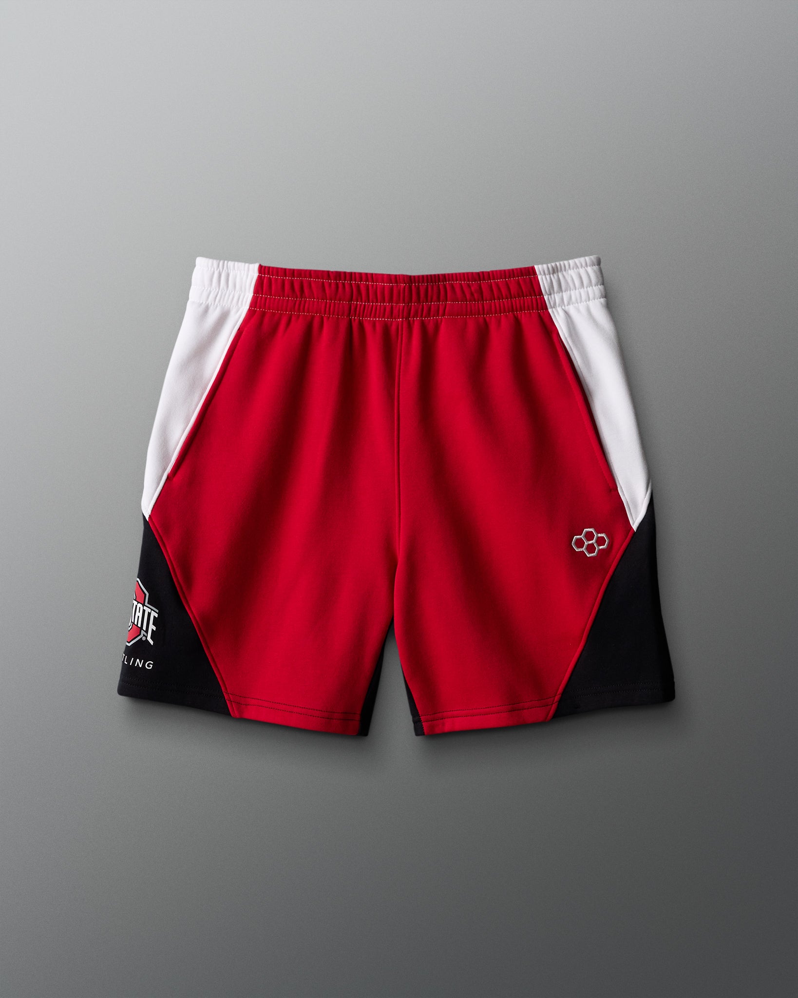Red and black athletic shorts with white accents on a gray background