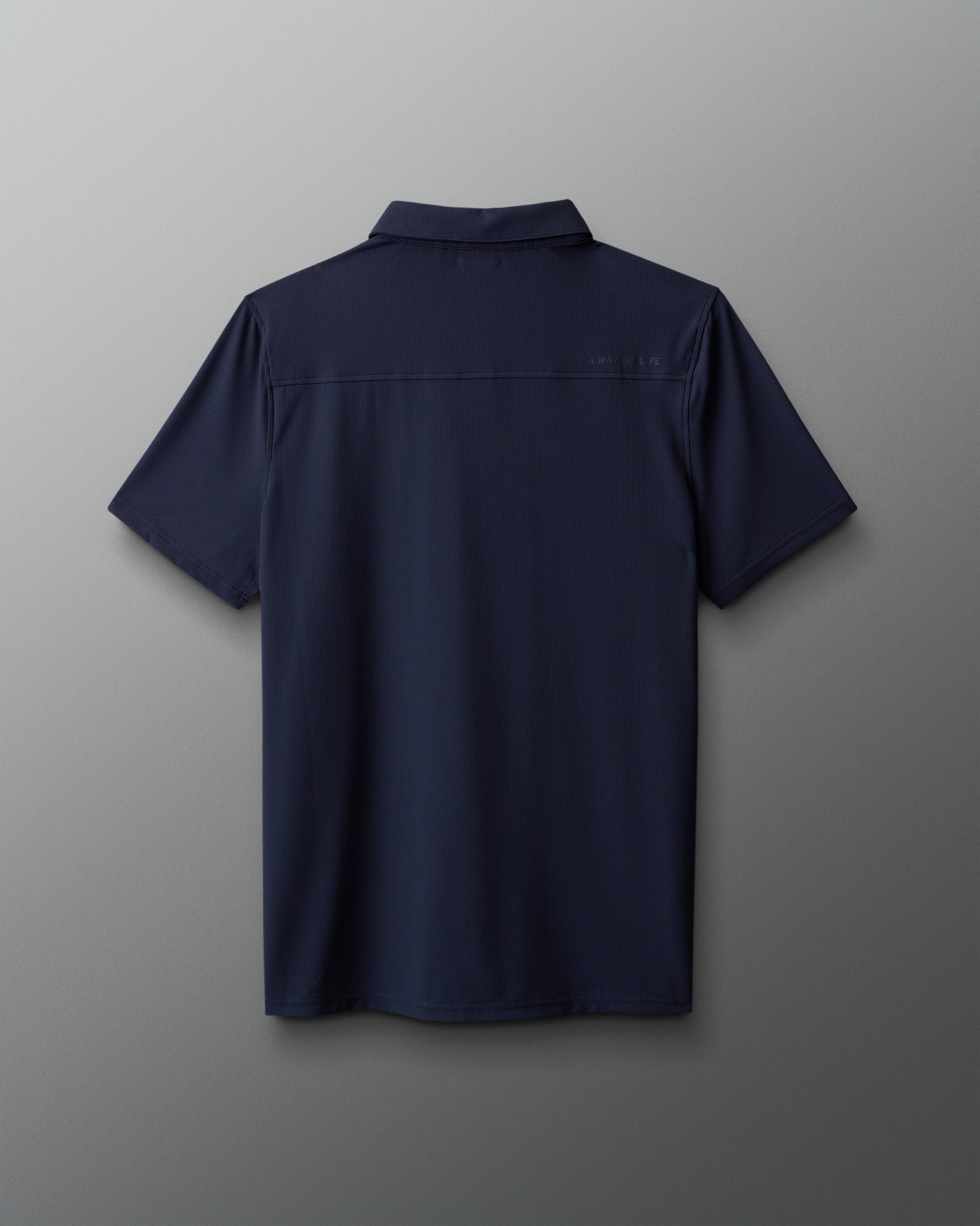 Navy blue polo shirt on a gray background