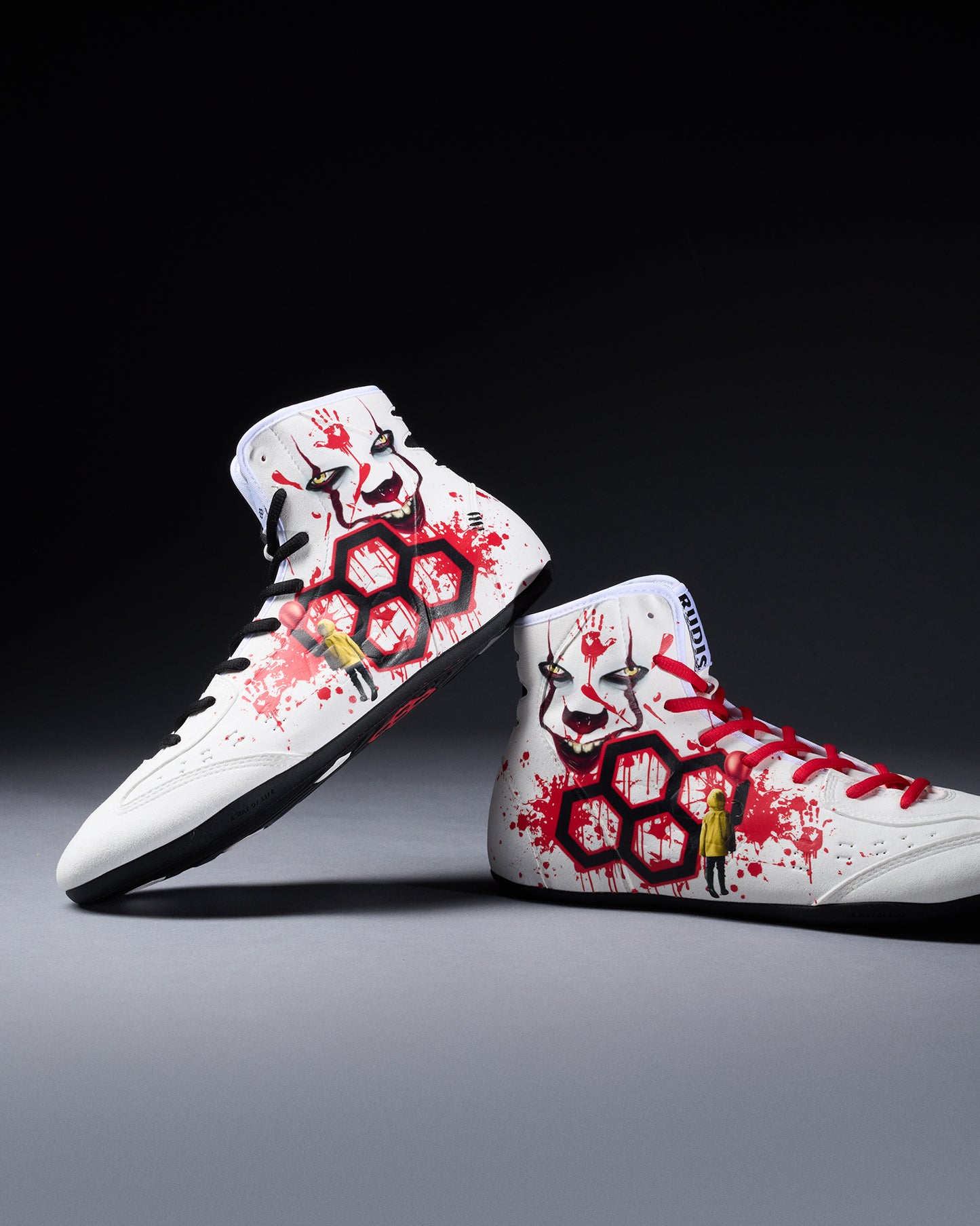 White wrestling shoes with red and black designs on a gray background