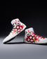 White wrestling shoes with red and black designs on a gray background