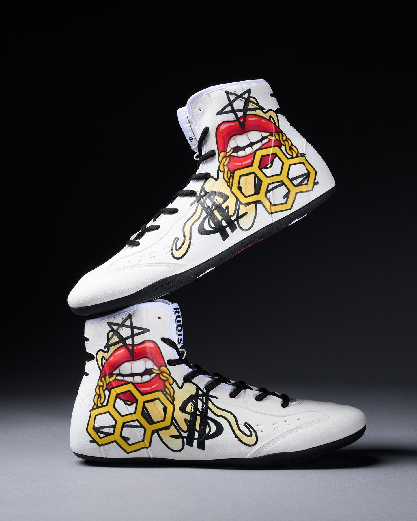 White wrestling shoes with colorful designs on a black and gray gradient background