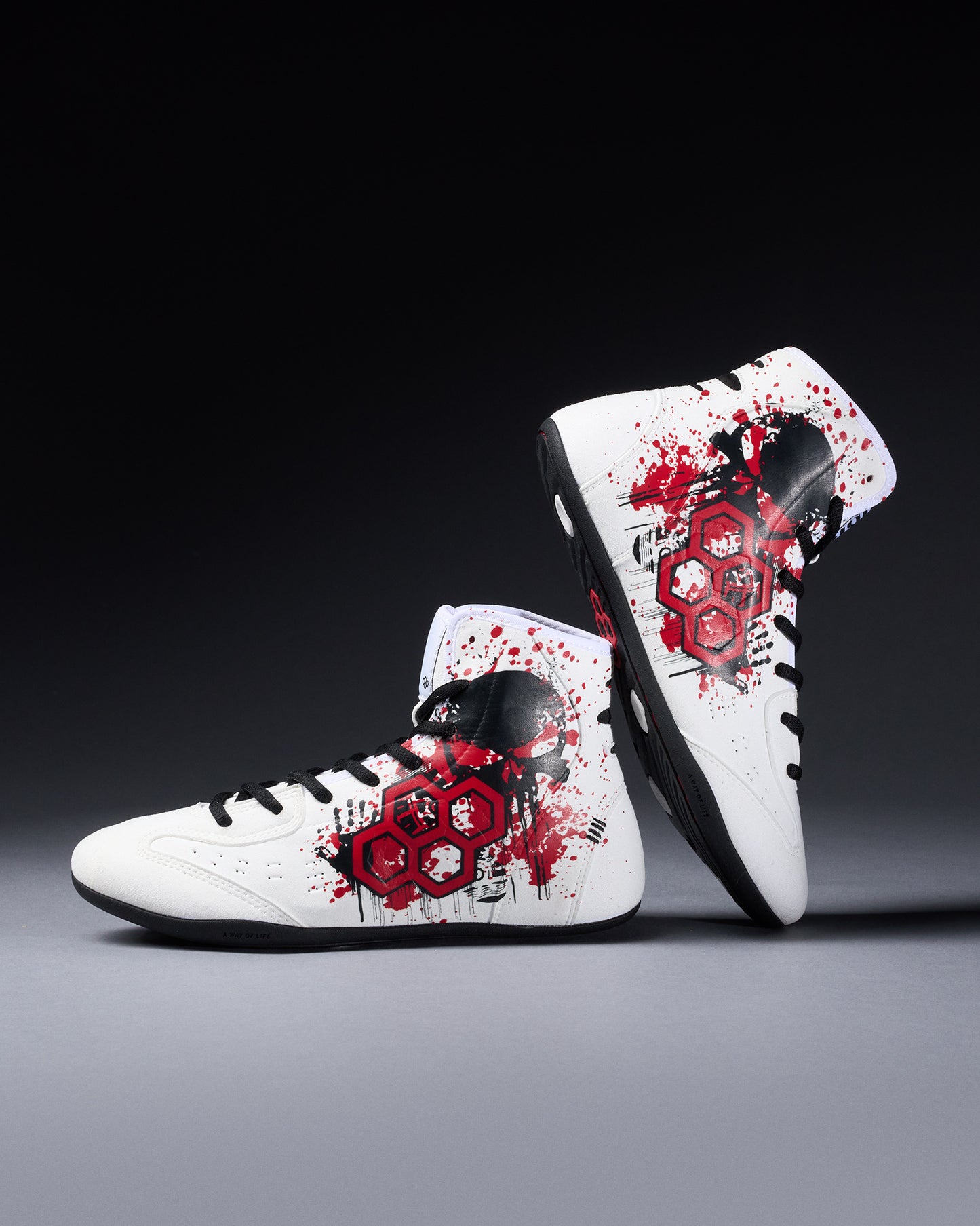White wrestling shoes with red and black floral patterns on a gray background