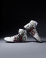 White wrestling shoes with black and red graphics on a dark background