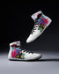 White wrestling shoes with colorful alien and geometric designs on a dark background