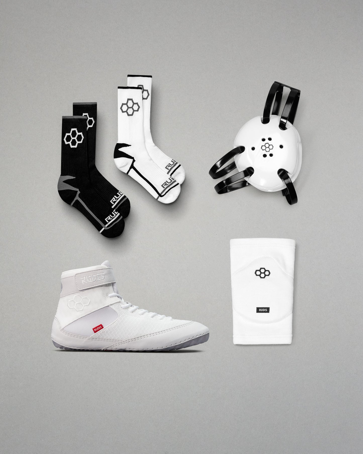 Collection of sports gear including wrestling shoes, socks, and accessories on a gray background