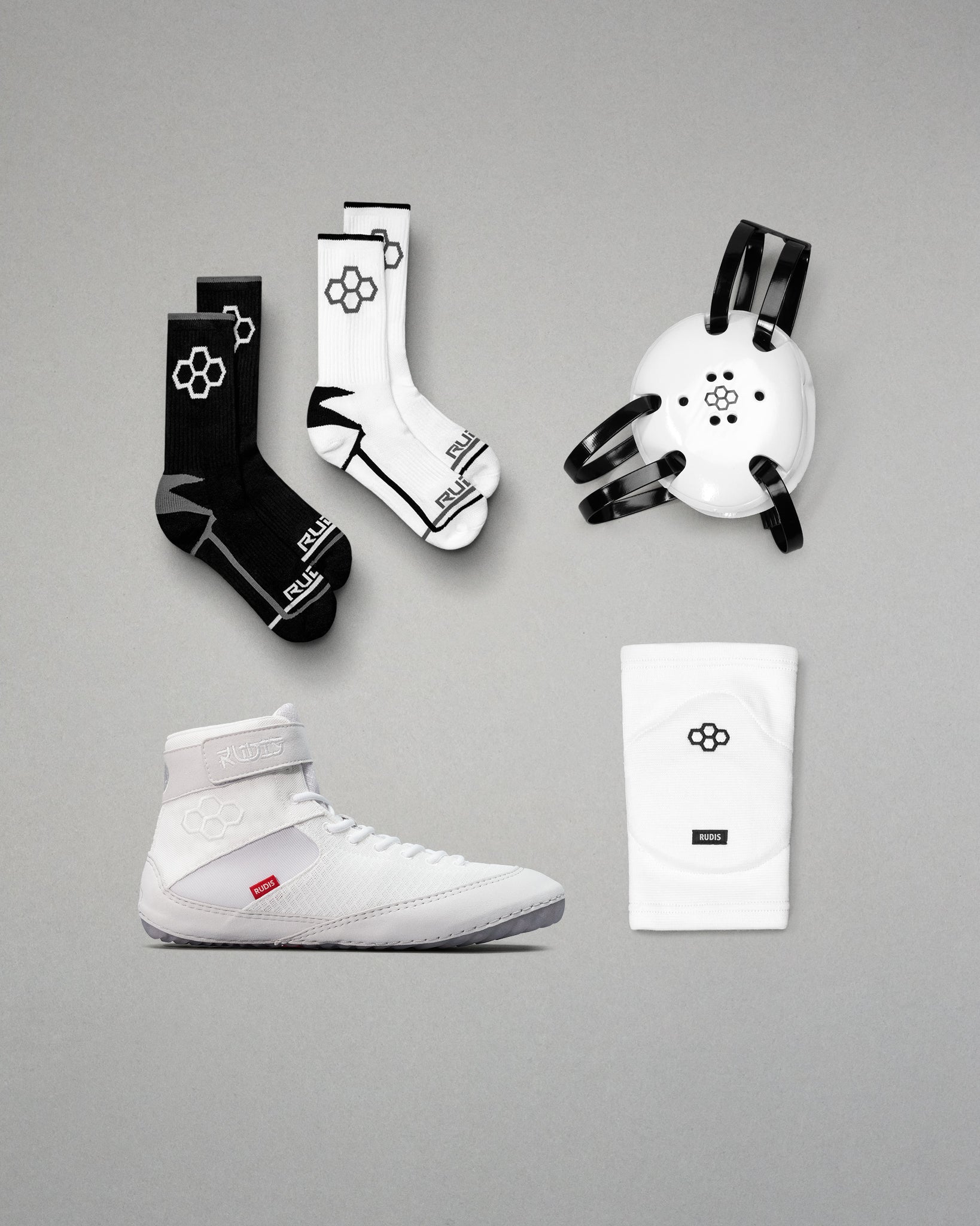 Collection of sports gear including wrestling shoes, socks, and accessories on a gray background