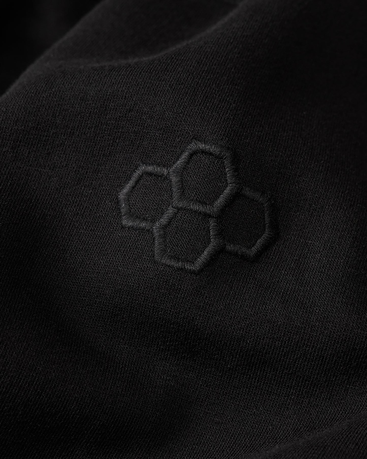 Black fabric with embroidered hexagonal pattern
