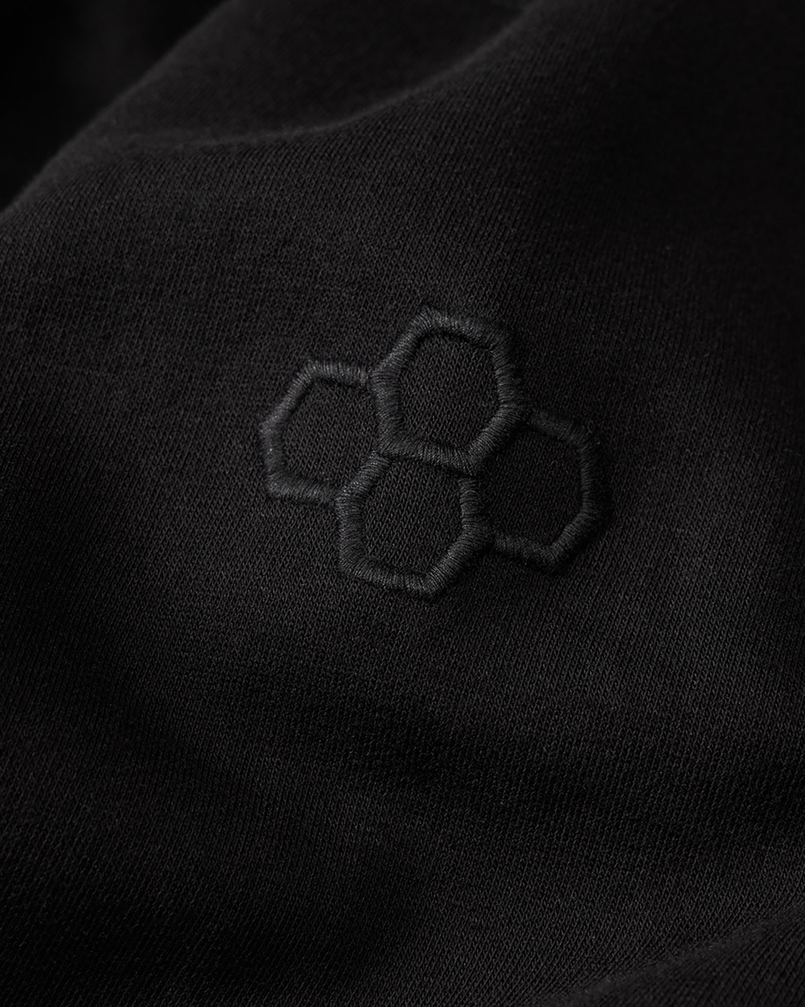 Black fabric with embroidered hexagonal pattern