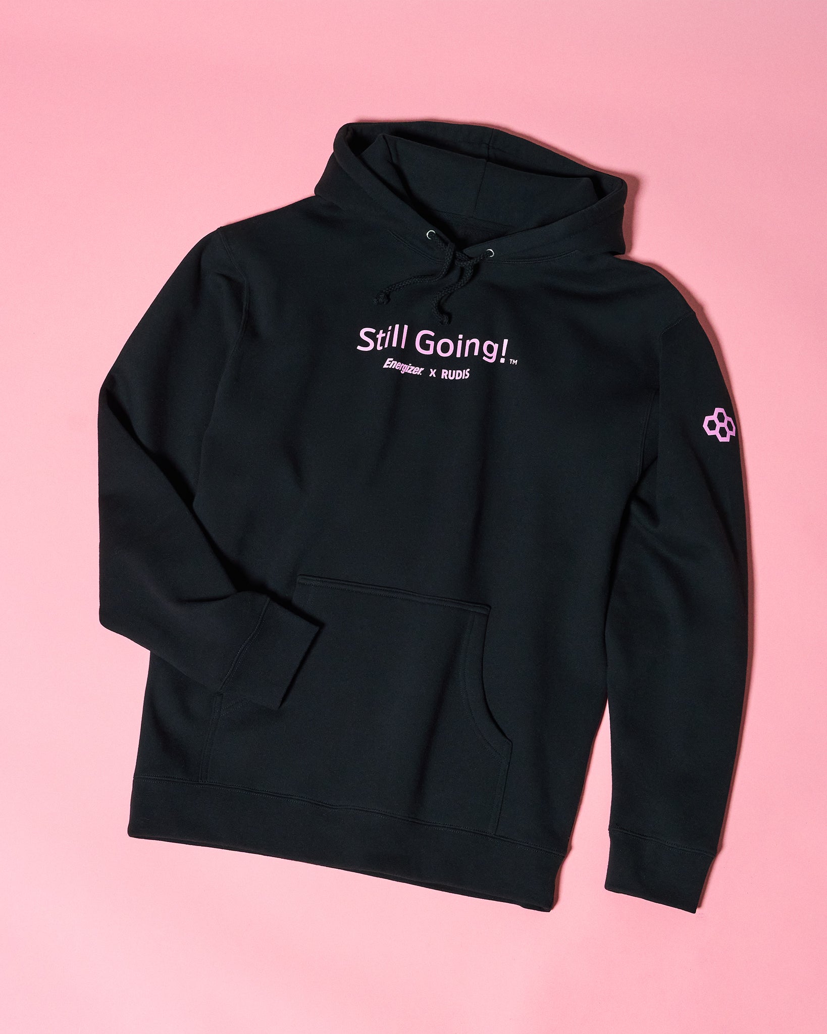 Black hoodie with 'Still Going!' text on a pink background