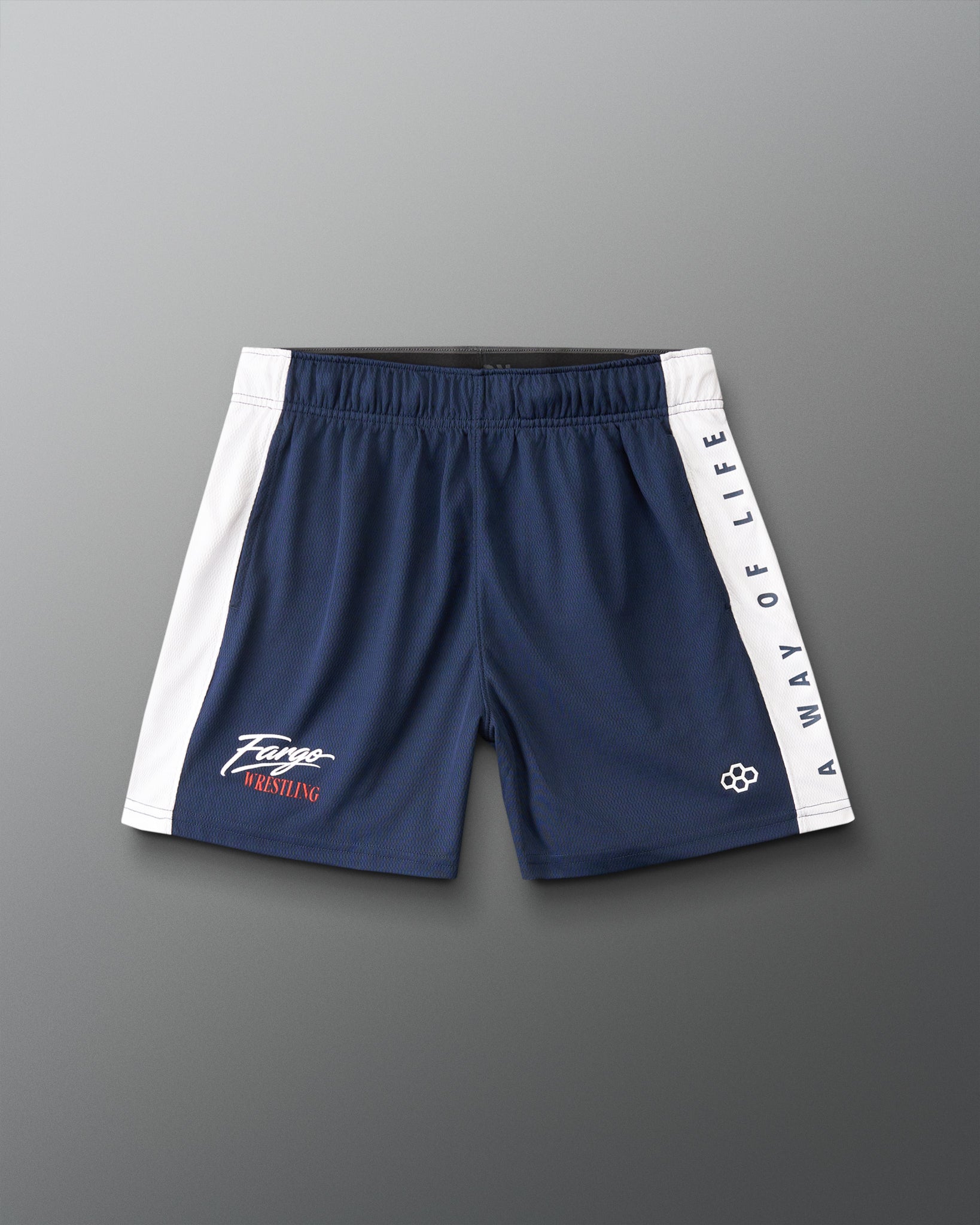 A pair of navy blue athletic shorts with white side panels and white text reading 'A WAY OF LIFE' down one leg, laid flat on a gray background.