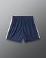 Navy blue athletic shorts with white side stripes, shown flat against a gray gradient background.