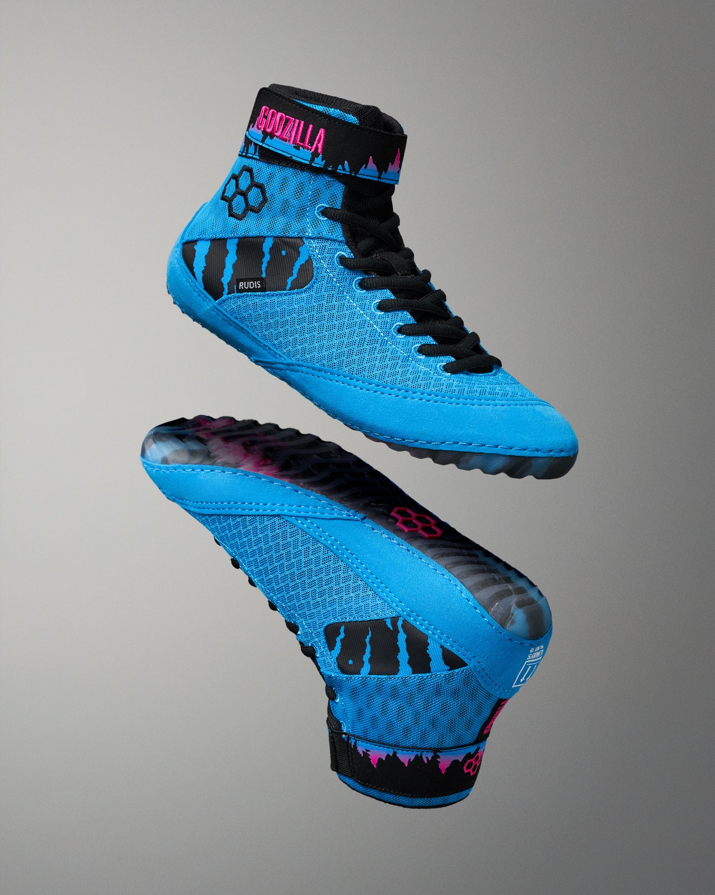 A pair of high-top wrestling shoes in bright blue with black details and pink accents, shown from the side and sole views against a neutral gray background.