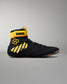 A black high-top wrestling shoe with bright yellow accents, including yellow stripes on the side, a yellow ankle strap with the brand name 'KONG' in black, and a yellow geometric logo, shown against a neutral gray background.
