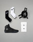 Black and white socks, black wrestling shoes, and a headgear on a gray background.