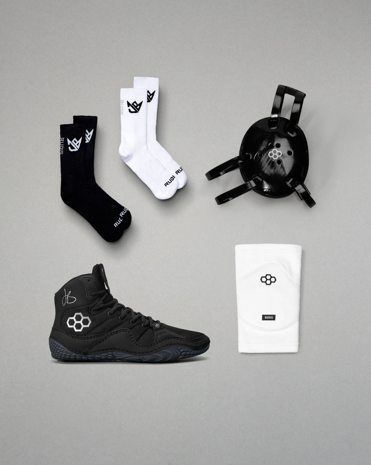 Black and white socks, black wrestling, and a black headgear on a gray background.