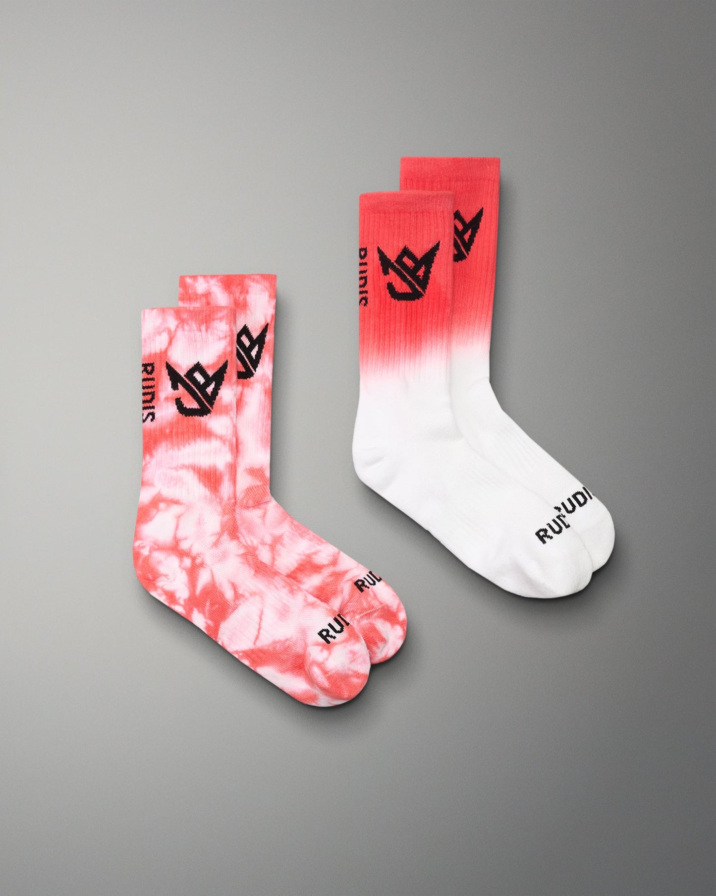 Two socks with tie-dye and gradient design on a gray background