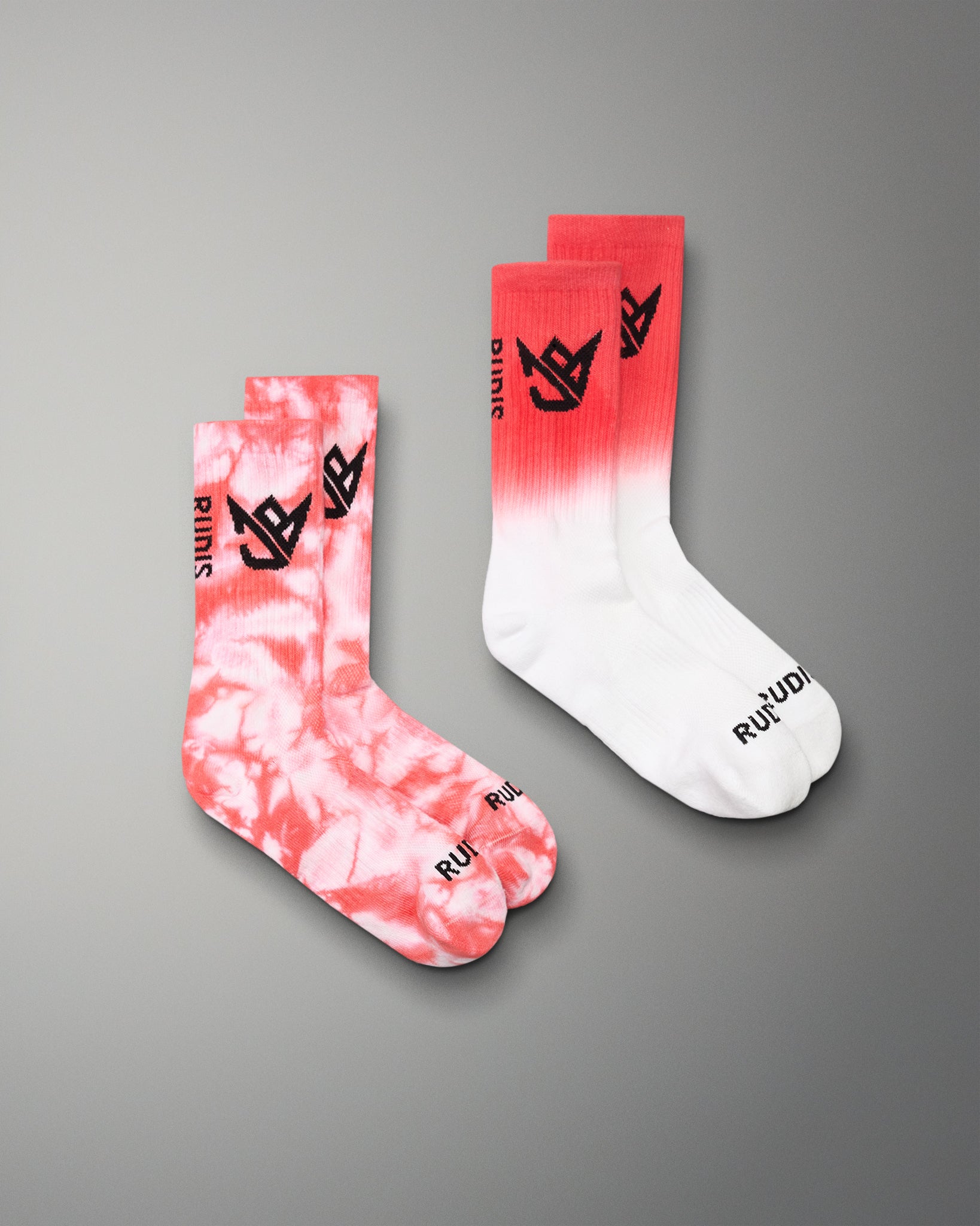 Two socks with tie-dye and gradient design on a gray background