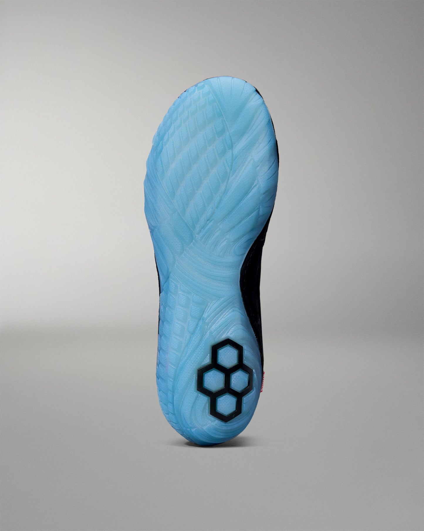 Blue wrestling shoe sole with a hexagonal pattern on a gray background
