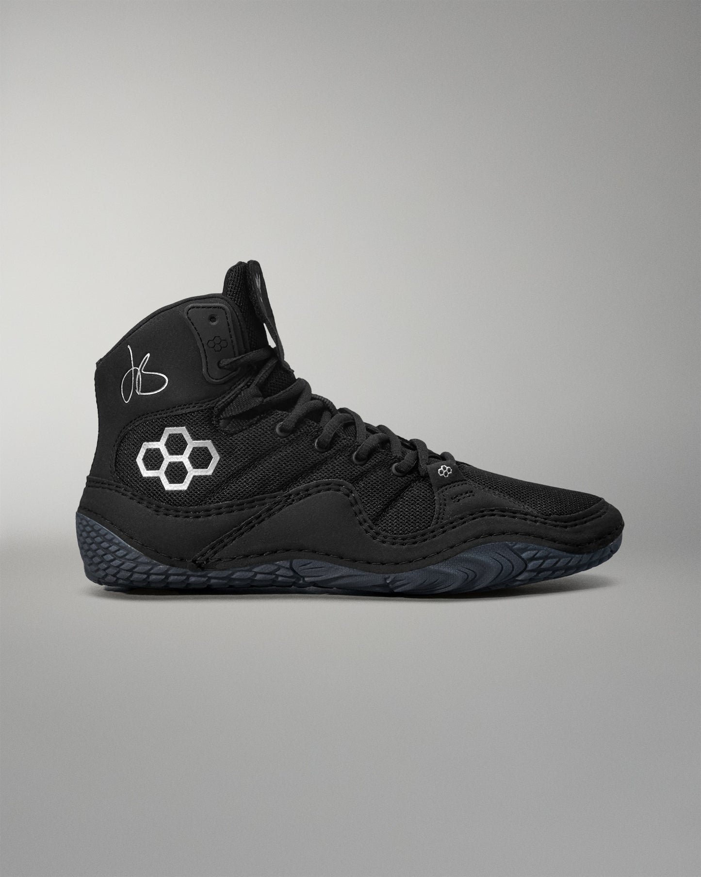 Black Jordan Burroughs wrestling shoes with a logo on a gray background