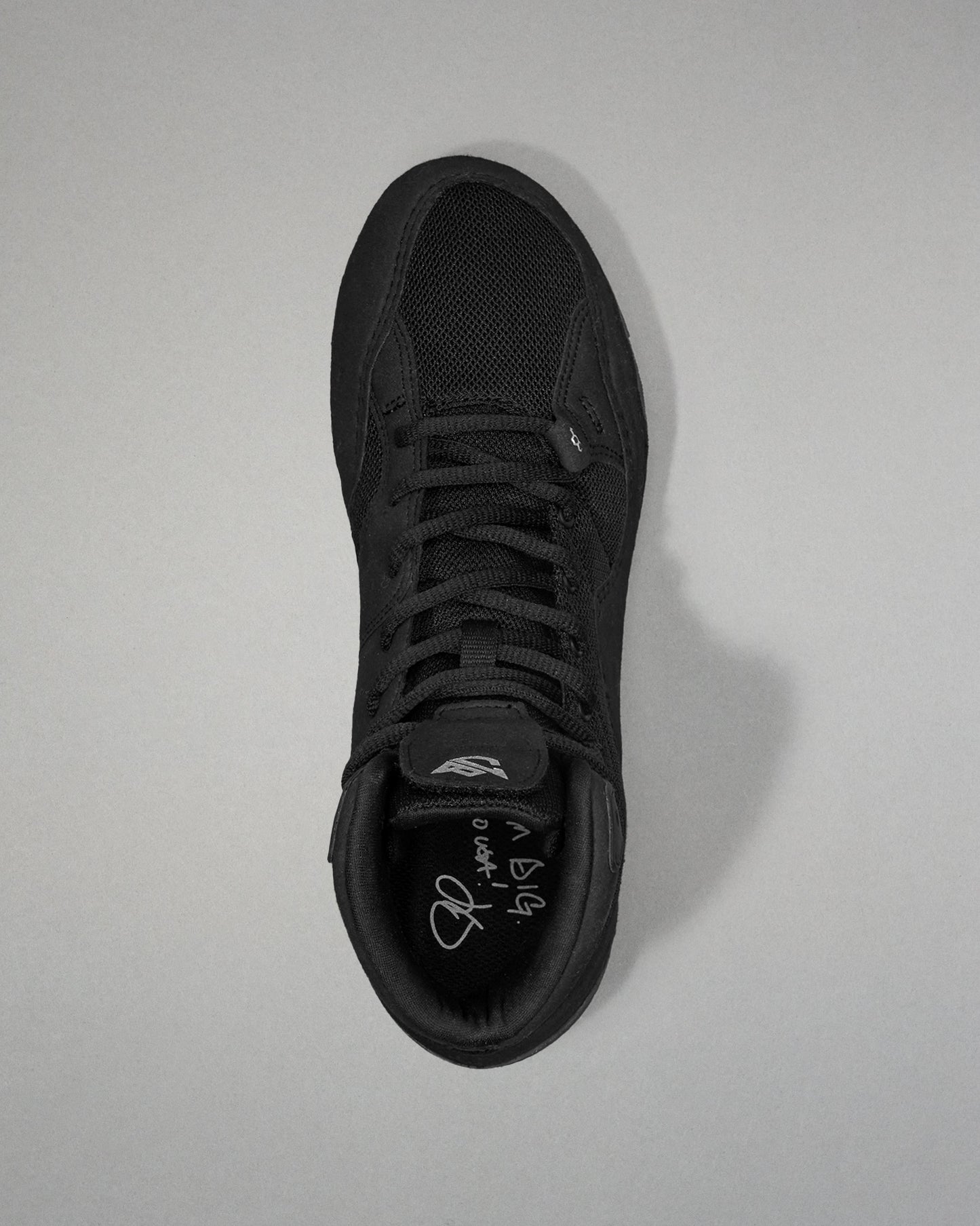 Black Jordan Burroughs wrestling shoes on a light gray background