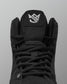 Black Jordan Burroughs wrestling shoes with a brand logo on a gray background