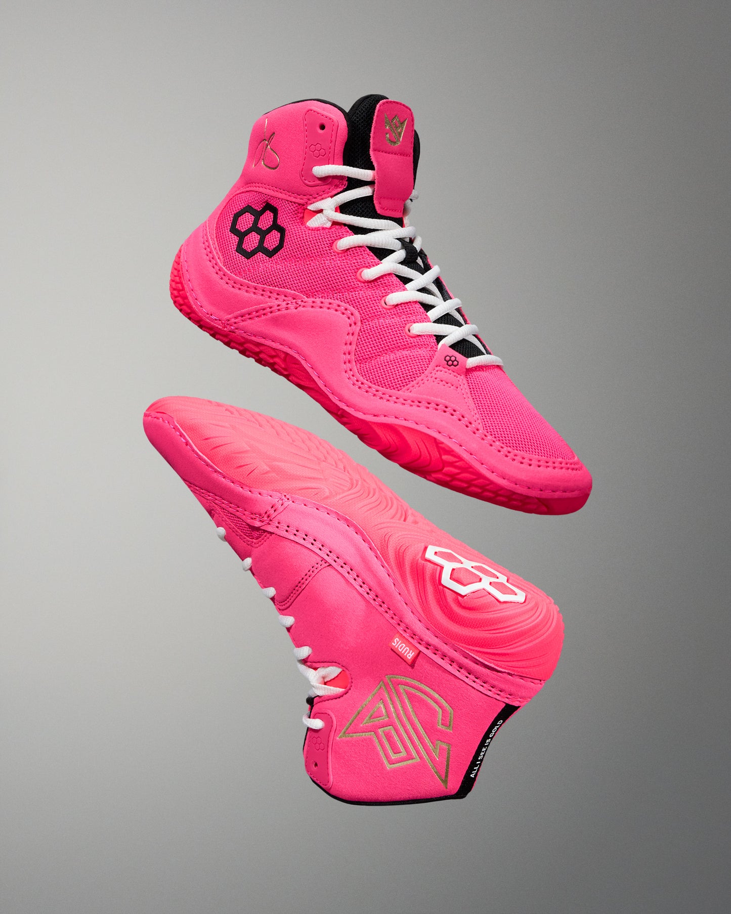 Pink wrestling shoes with white laces on a gray background