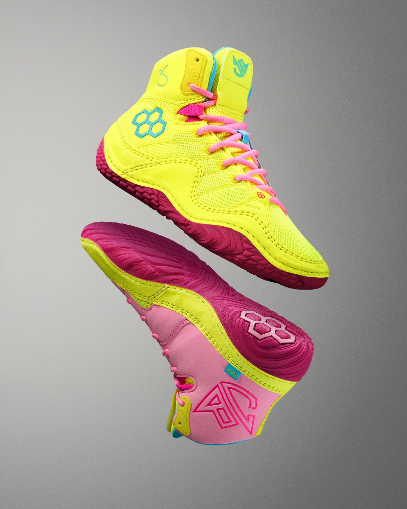 Neon yellow and pink wrestling shoe on a gray background