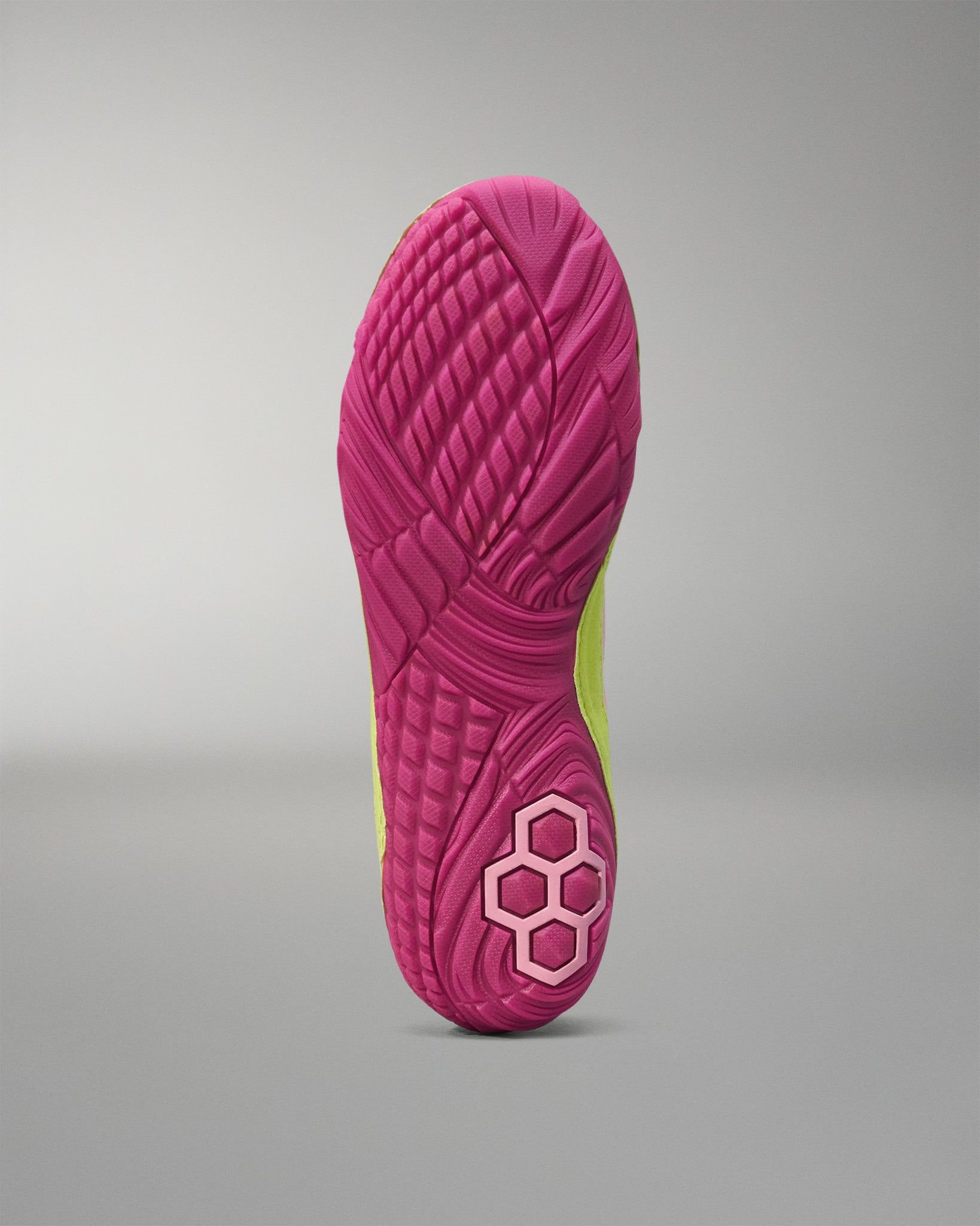 Close-up of a pink Wrestling shoe sole with a textured pattern on a gray background