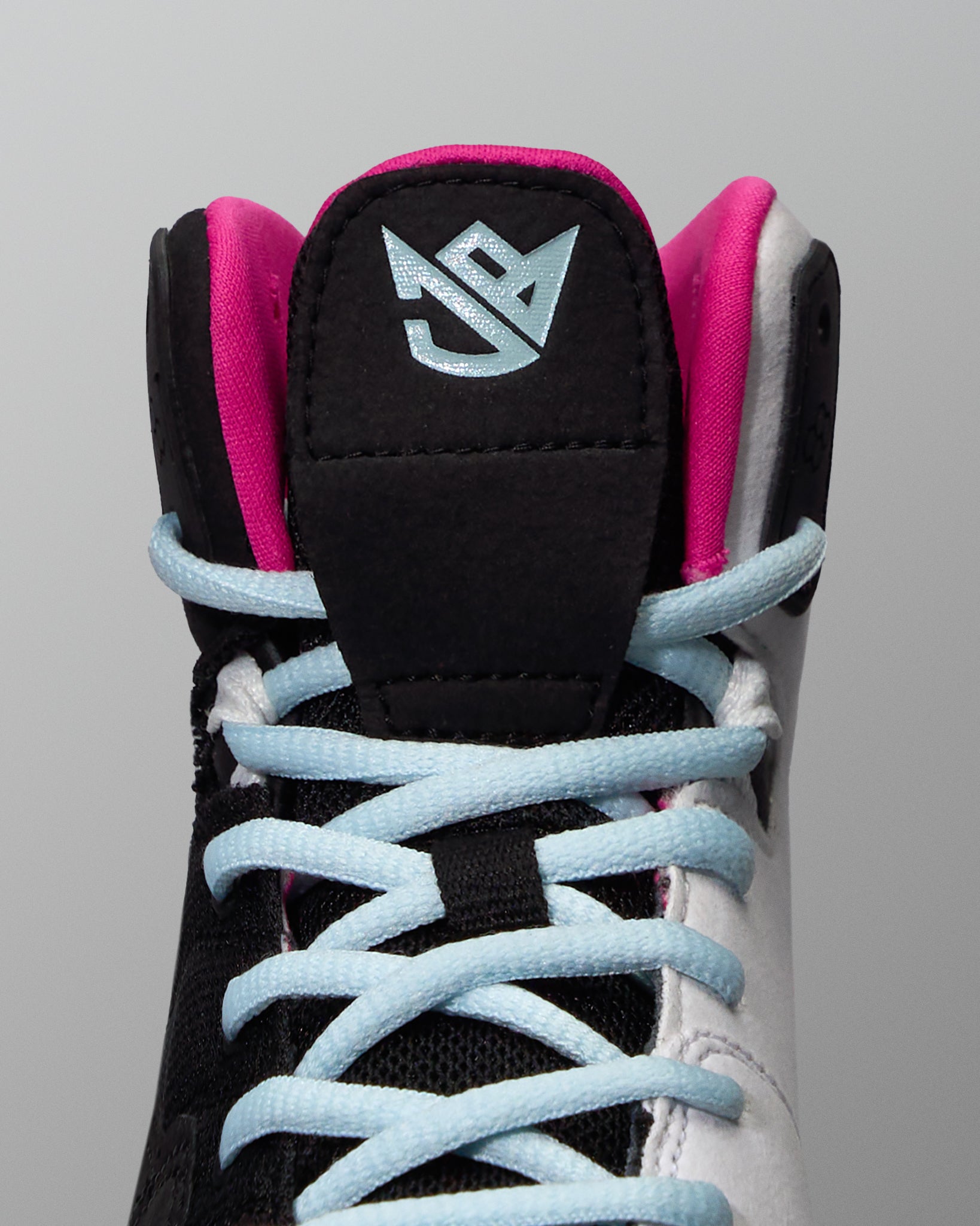 Black and pink wrestling shoe with light blue laces on a gray background